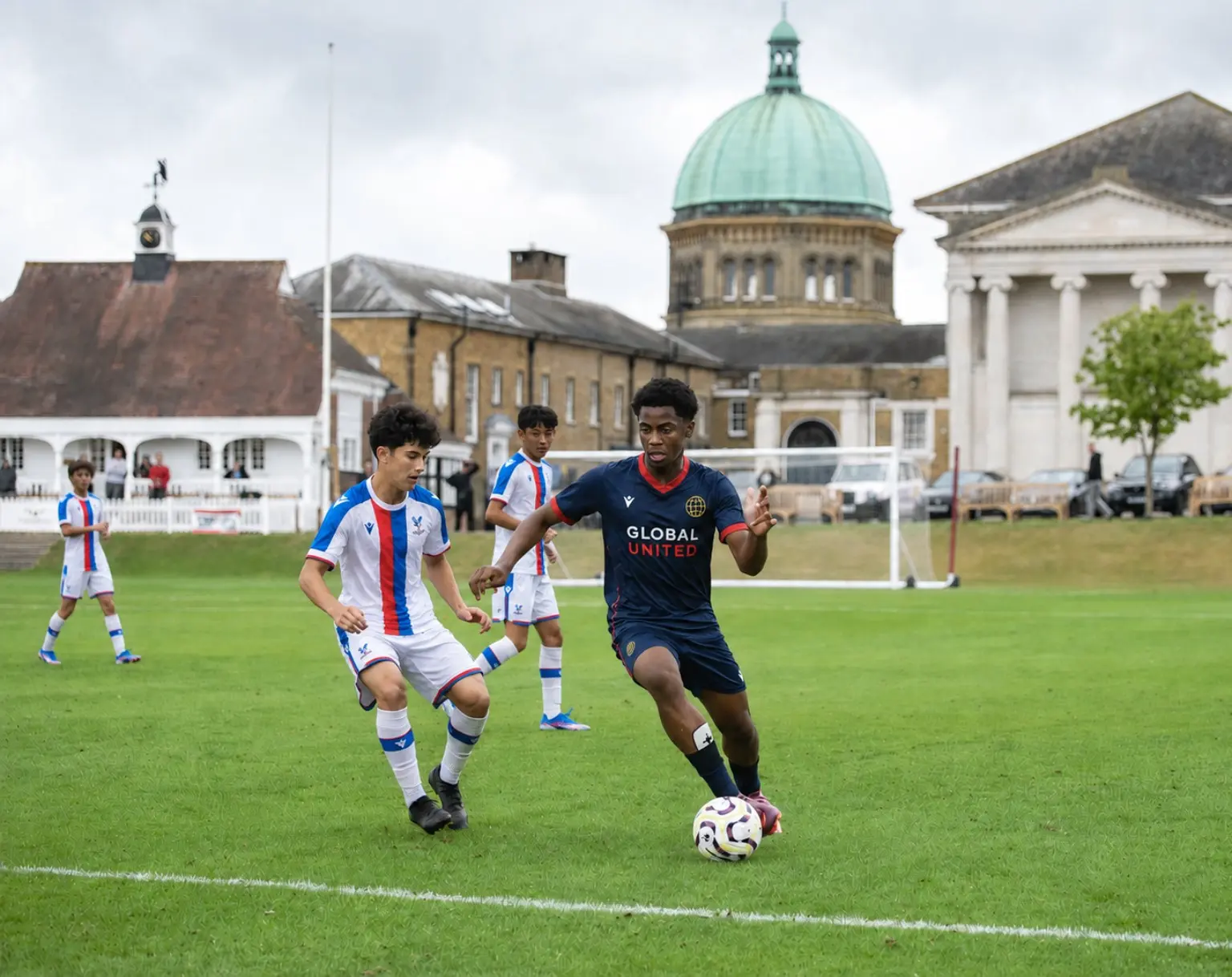 A Global United player carrying the ball against English opposition at Haileybury